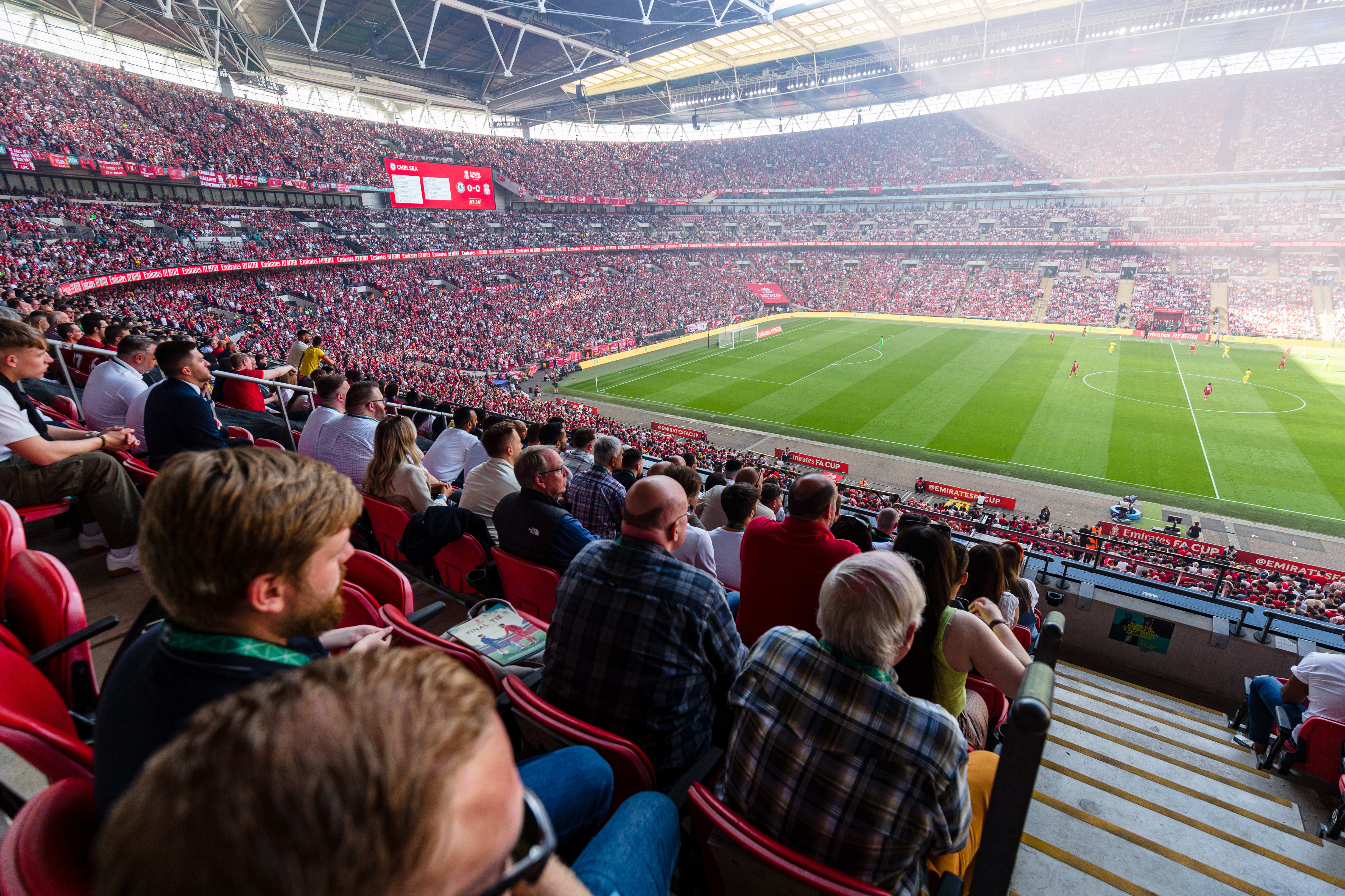 Fans watching football match at Wembley Stadium