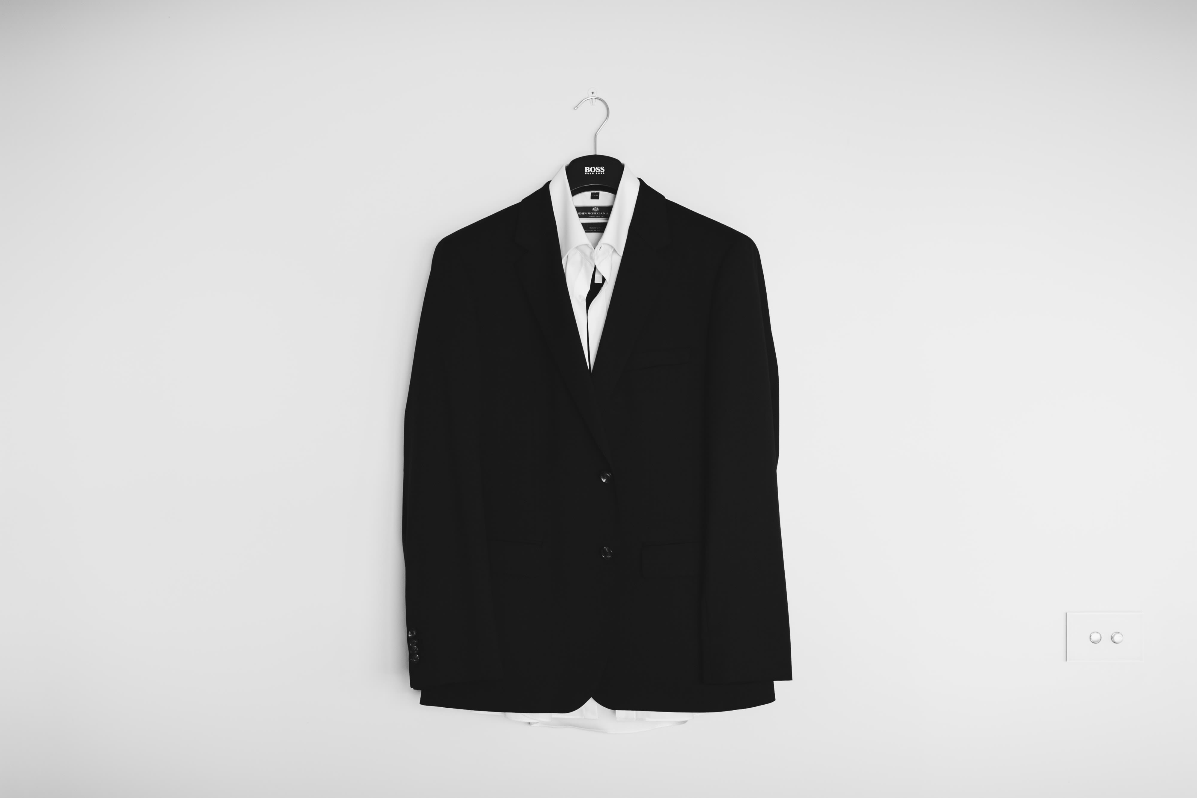 Suit jacket and shirt hanging up on a wall 