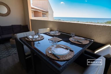 Terrasse avec salon de jardin, plancha, vue sur la piscine et la Méditerranée