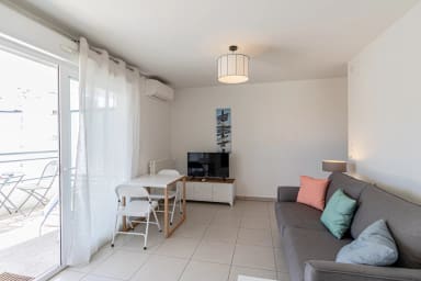 Salon/Salle à manger avec canapé/lit, table et chaises et télévision.