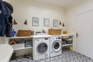 Buanderie équipée d'un lave linge et d'un sèche linge