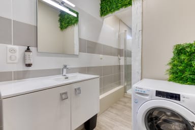 Salle de bain avec douche et machine à laver