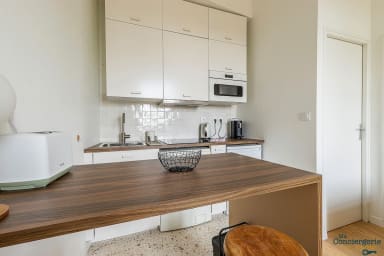 espace cuisine avec coin repas, machine à laver, micro-ondes, bouilloire,...