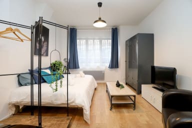 Coin nuit avec lit double, placard de rangement et TV