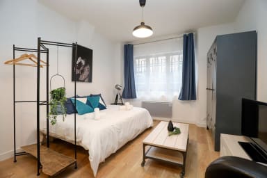 Pièce à vivre avec lit double, placard de rangement et TV