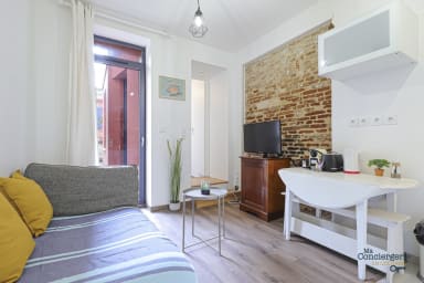 Espace séjour avec coin salon, tv, coin repas et kitchenette équipée