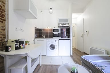 Espace séjour avec coin salon, tv, coin repas et kitchenette équipée