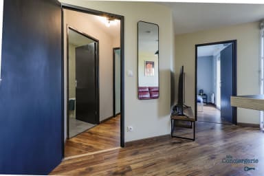 Séjour donnant sur le balcon, la 2ème chambre ainsi que le couloir qui mène...