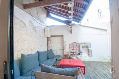 Terrasse intime et chaleureuse avec sièges confortables et table basse rouge...