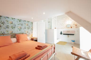 Chambre spacieuse sous les combles avec lit queen size. Décorée de briques...