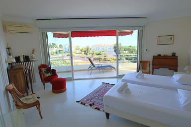 Large, air-conditioned bedroom with two single beds, opening onto a terrace.