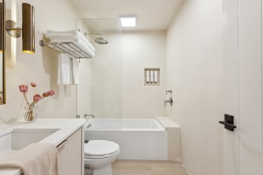 En-suite bathroom with rain shower, bathtub, and high-end toiletries