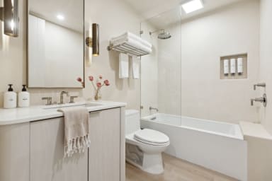 En-suite bathroom with rain shower, bathtub, and high-end toiletries