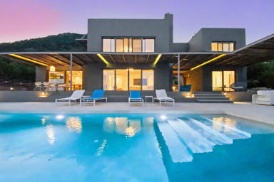 Lounge by the illuminated pool at dusk and feel evening serenity set in.