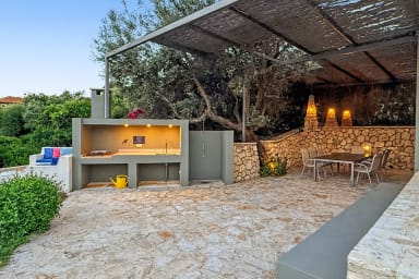 Le soir, cuisine d’extérieur conviviale sous l'éclairage doux du jardin.