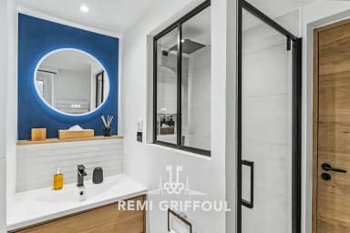Salle d’eau design dotée d’une grande douche et miroir rétroéclairé moderne