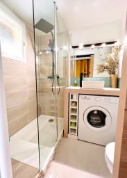 La salle de bain avec une machine à laver.