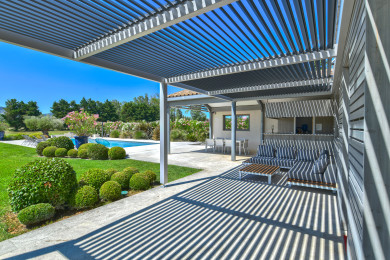 Terrasse ombragée avec salon de jardin et cuisine