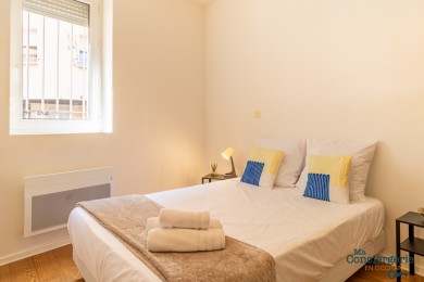 Chambre à coucher avec fenêtre donnant sur une petite rue