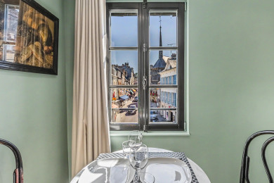 Salle à manger lumineuse avec vue sur la ville, ambiance urbaine chic.
