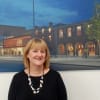 Helen Green in front of an artist's impression of the Fire Station/Auditorium complex