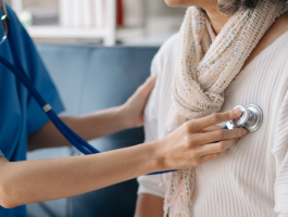 Eine Ärztin hört mit einem Stethoskop die Lunge einer Patientin ab – Symbolbild für medizinische Untersuchung und bessere Versorgung bei seltenen Krankheiten.