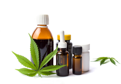 Mehrere Flaschen und Behälter mit verschiedenen verschlossenen Deckeln, gefüllt mit Flüssigkeiten, begleitet von zwei grünen Cannabisblättern, auf einem weißen Hintergrund.