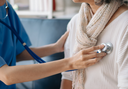 Eine Ärztin hört mit einem Stethoskop die Lunge einer Patientin ab – Symbolbild für medizinische Untersuchung und bessere Versorgung bei seltenen Krankheiten.