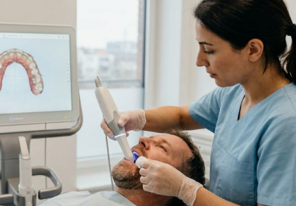 Eine zahnmedizinische Fachangestellte erstellt den digitalen Zahnabdruck eines Patienten.