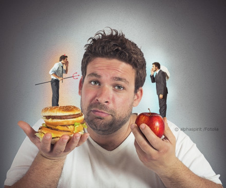 Ein Mann mit einem unschlüssigen Gesichtsausdruck hält in der einen Hand einen Hamburger und in der anderen Hand einen Apfel. Auf seinen Schultern sitzen kleine Figuren, die wie ein Teufelchen und ein Engel aussehen, die ihm ins Ohr flüstern.