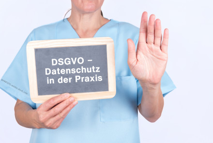 Eine Person in blauer medizinischer Kleidung hält ein Schild mit der Aufschrift "DSGVO - Datenschutz in der Praxis" in der linken Hand und hebt die rechte Hand zur Seite.