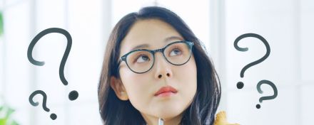 Eine Frau überlegt. Neben ihrem Kopf mehrere Fragezeichen.