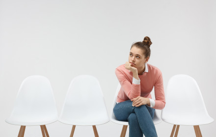 Patientin wartet unzufrieden im Wartezimmer einer Zahnarztpraxis – Symbolbild für Patientenfrust, lange Wartezeiten und Patientenverlust in der Praxis