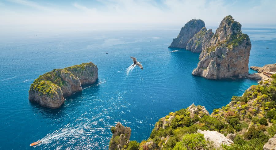 Enchanting Travels Italy Tours Aerial view of famous Faraglioni rocks from Capri island, Italy.