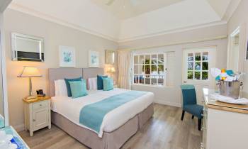 a bedroom with a bed and desk in a room