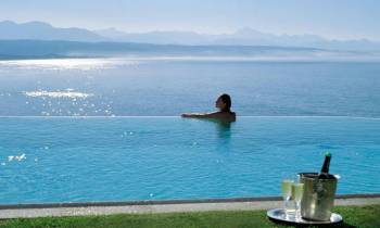 a person sitting next to a body of water next to the ocean