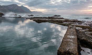 a body of water with a mountain in the background