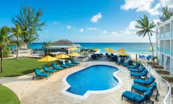 a group of lawn chairs sitting on top of a sandy beach