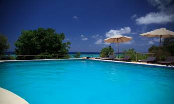 a group of lawn chairs sitting on top of a blue pool of water