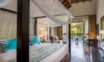 a bedroom with a bed and a chair in a room