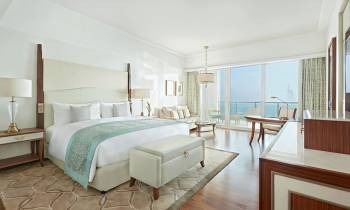 a bedroom with a bed and a chair in a room