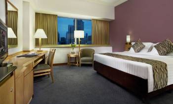 a bedroom with a bed and desk in a hotel room