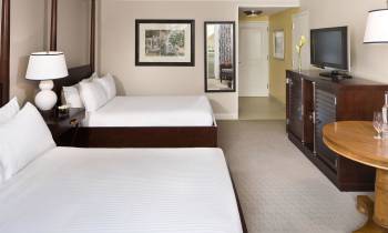 a bedroom with a bed and desk in a hotel room