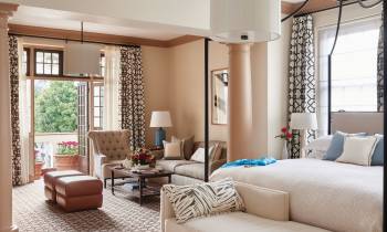 a bedroom with a bed and a chair in a room