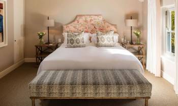 a bedroom with a bed and a chair in a room