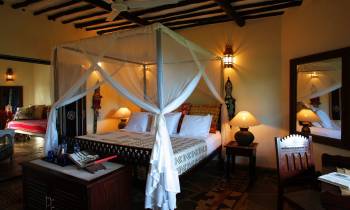 a bedroom with a bed and desk in a room