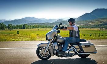 a man sitting on a motorcycle in front of a mountain