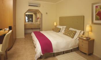 a bedroom with a bed and desk in a hotel room