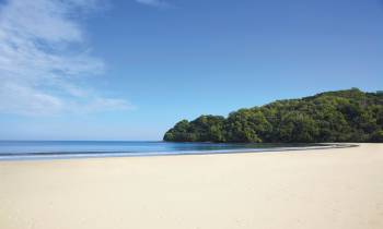 a sandy beach next to a body of water