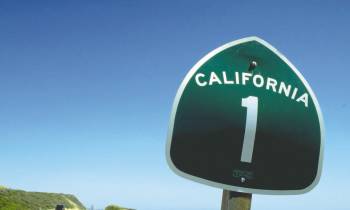 a close up of a street sign sitting on the side of a road